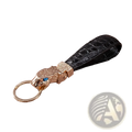 Black crocodile leather luxury keychain with gold-toned tiger head charm featuring a blue gemstone for car keys