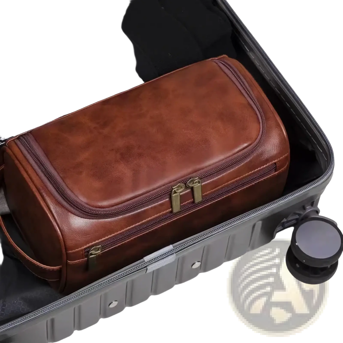Brown leather toiletry bag with brass-colored zippers and handle inside an open suitcase for travel dopp kit use