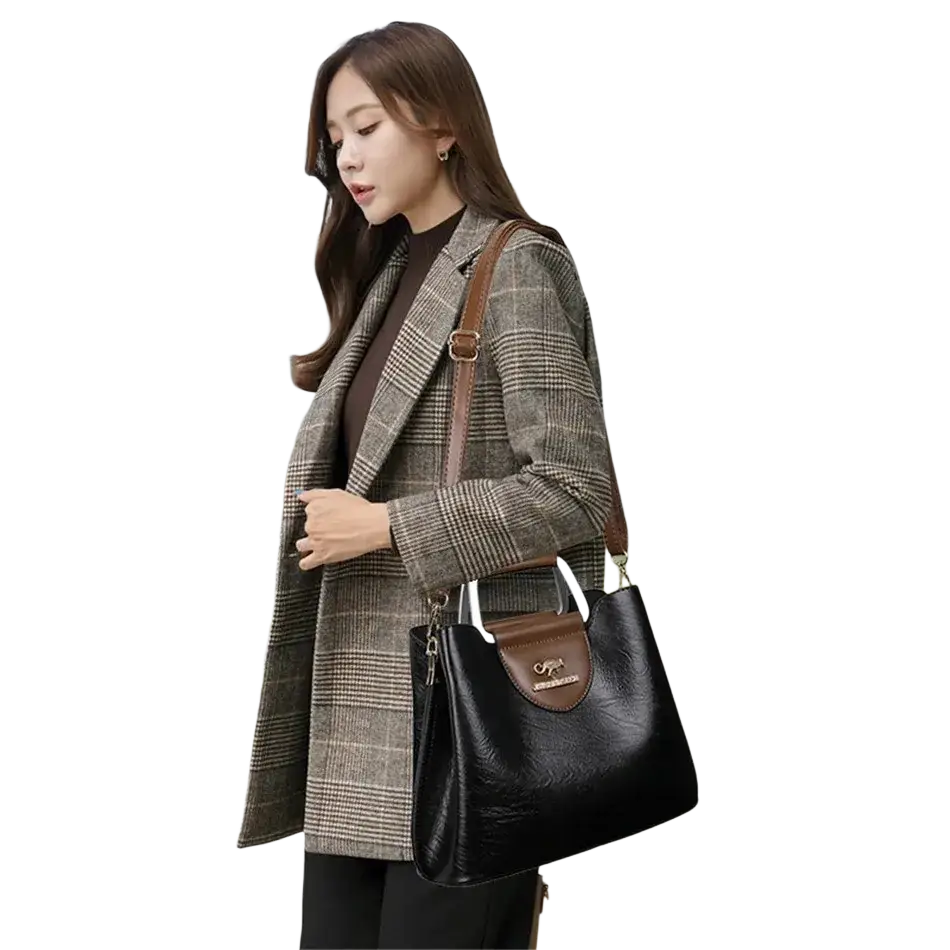 Black leather tote bag with brown accents and metallic logo plaque featuring a pocket interior for organization