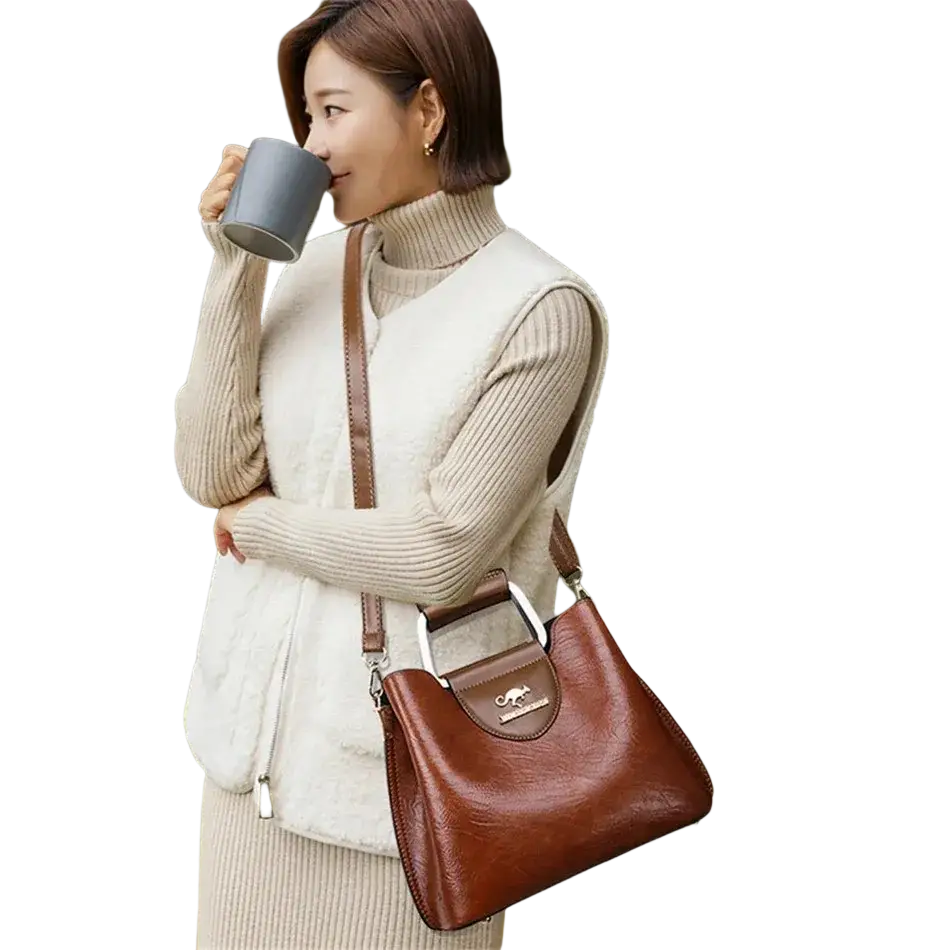 Brown leather tote bag with silver metal clasp and handle featuring a spacious pocket interior for organization