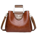 Brown leather tote bag with pocket interior, silver kangaroo logo plaque, and metal handle for stylish carrying