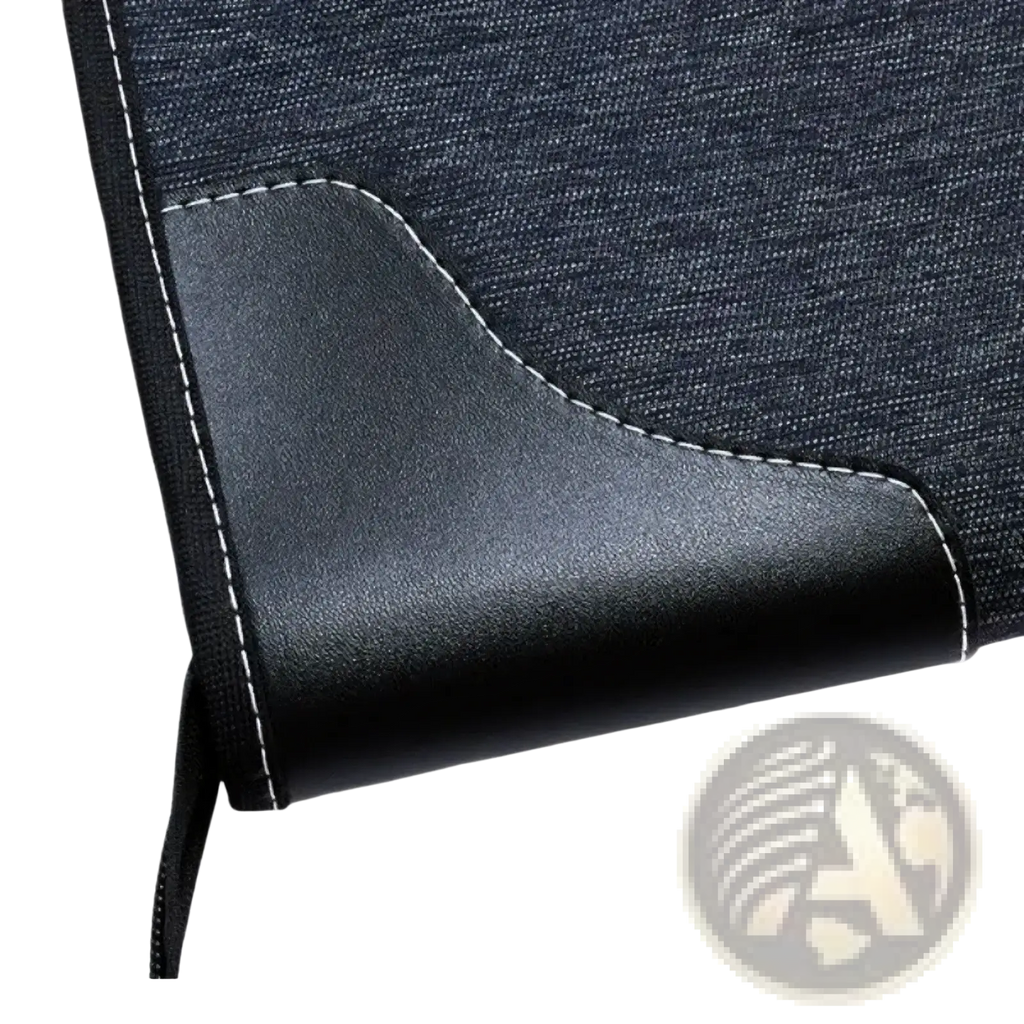 Black leather-trimmed corner of a dark denim leather travel garment bag with white stitching for business use