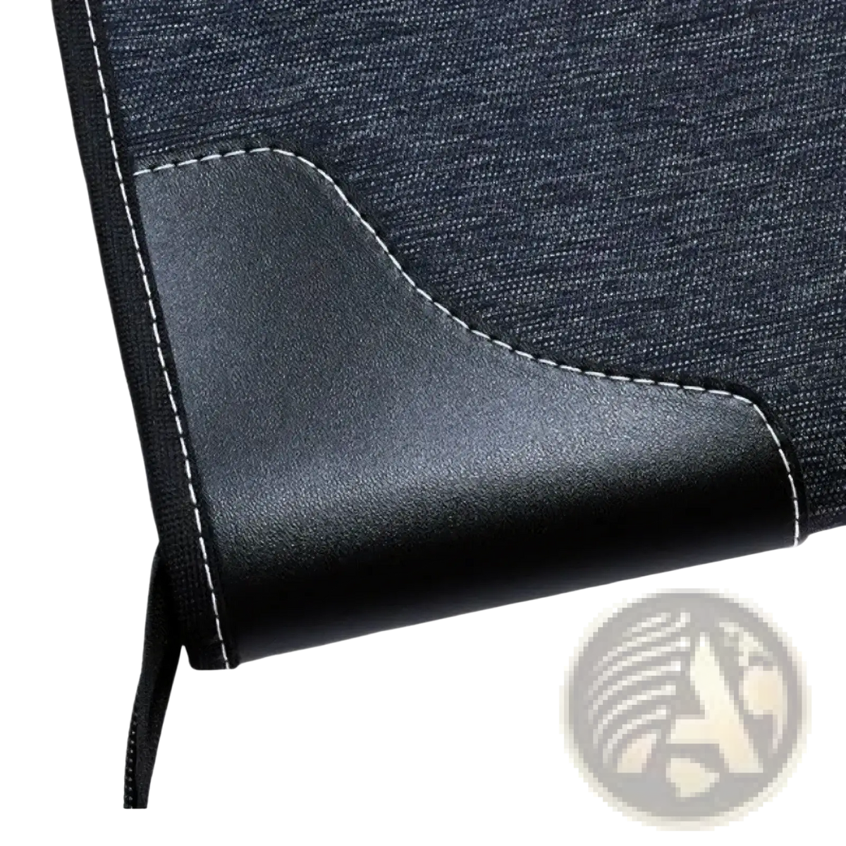 Black leather-trimmed corner of a dark denim leather travel garment bag with white stitching for business use