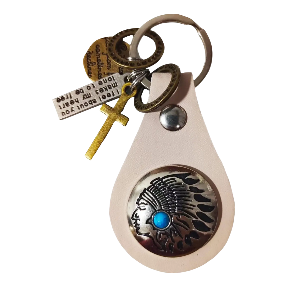 A cream leather keychain with a silver Native American chief medallion, turquoise stone, gold cross, and engraved tag charm