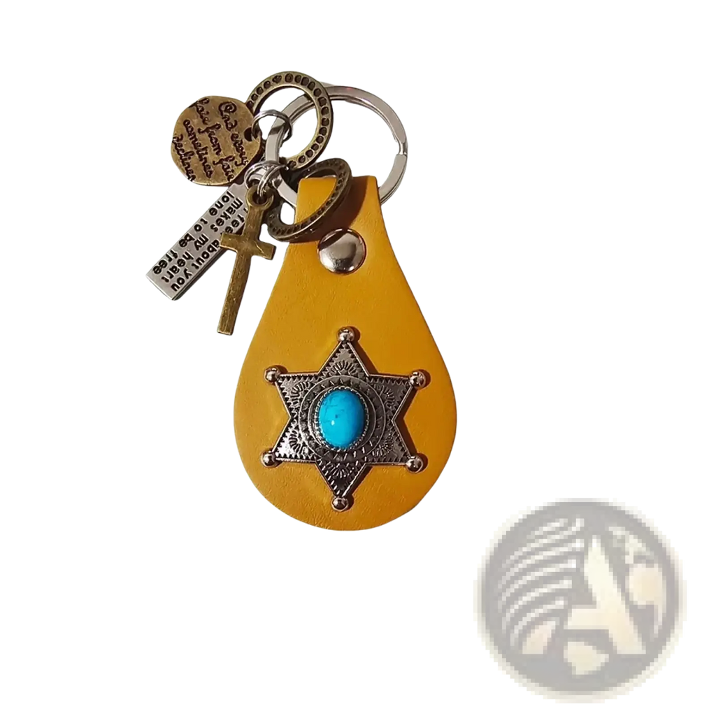 A yellow leather keychain featuring a silver star badge with turquoise stone and additional cross and metal tags charms