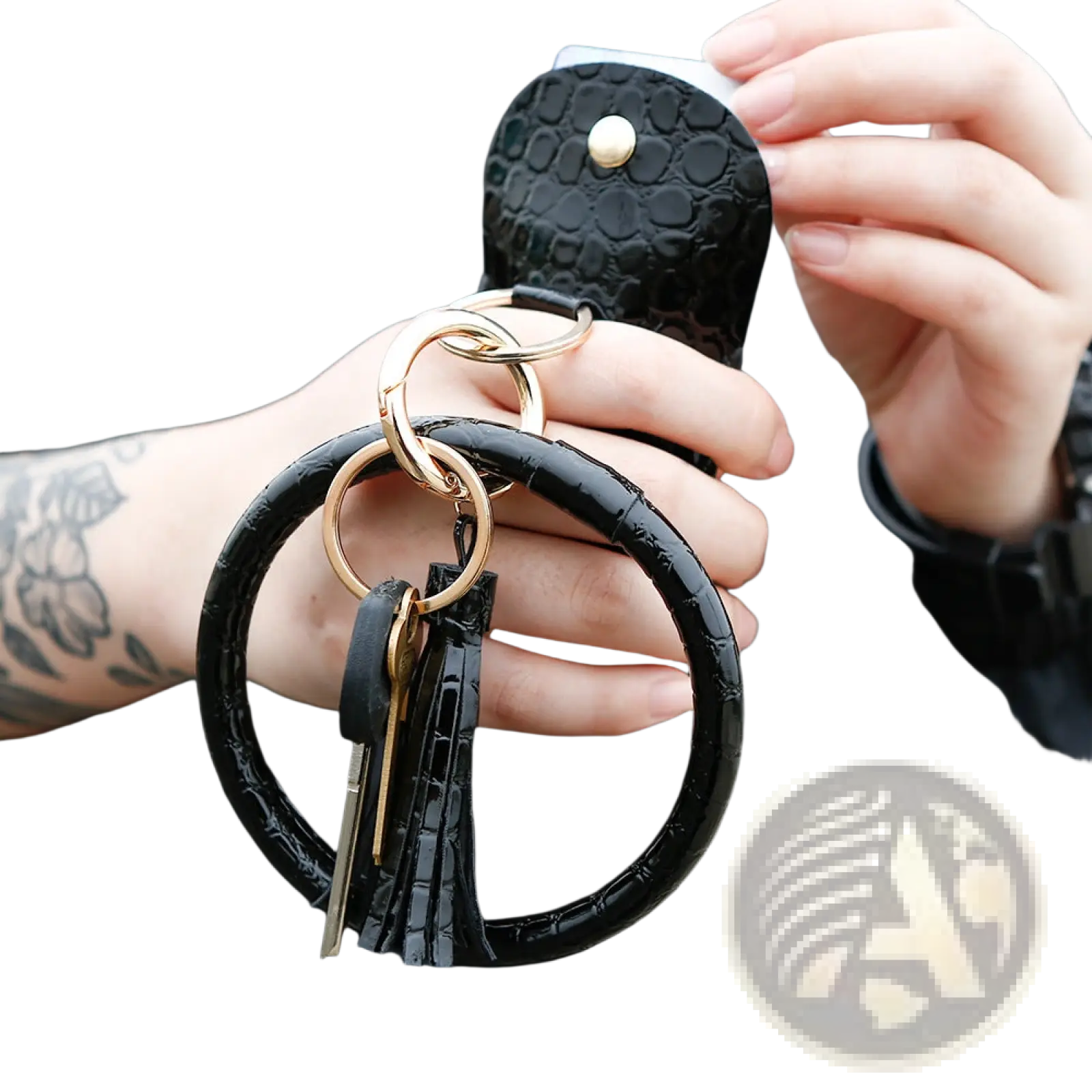 Black crocodile-textured leather wristlet keychain card holder with gold-toned rings and matching black tassel attached to wallet