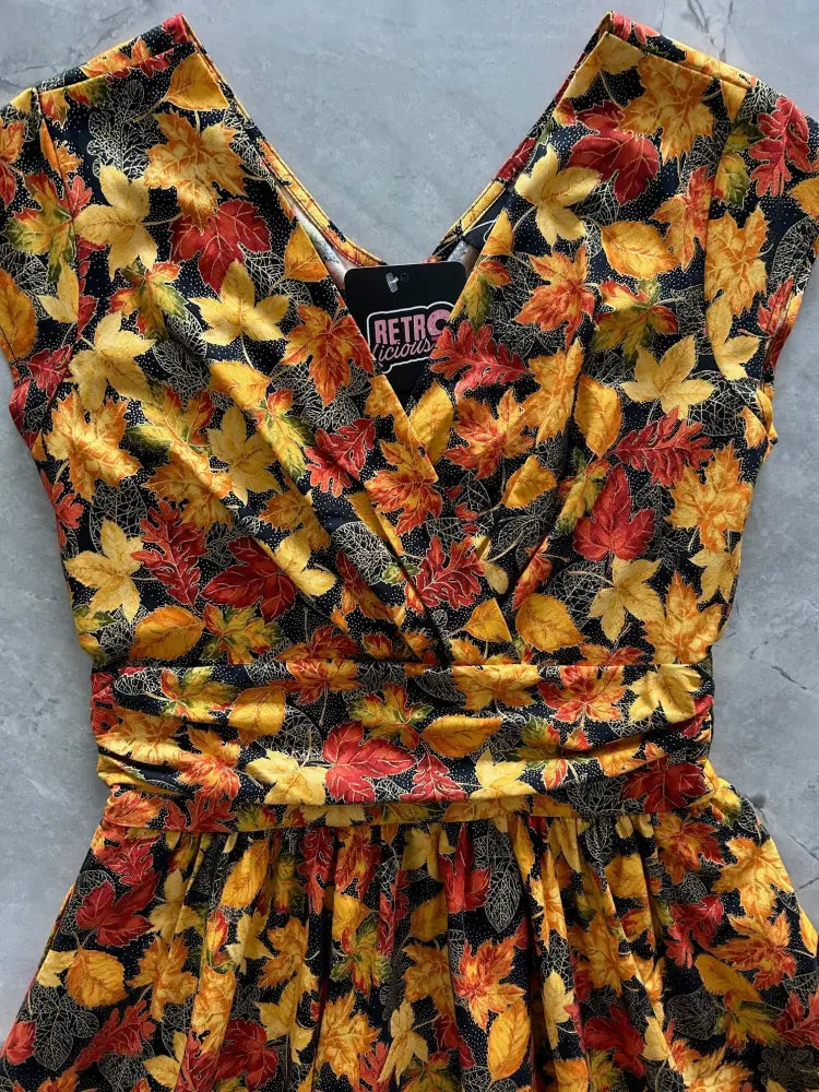 Greta autumn leaves cotton wrap dress with pockets featuring a vibrant yellow orange and red maple leaf pattern on black