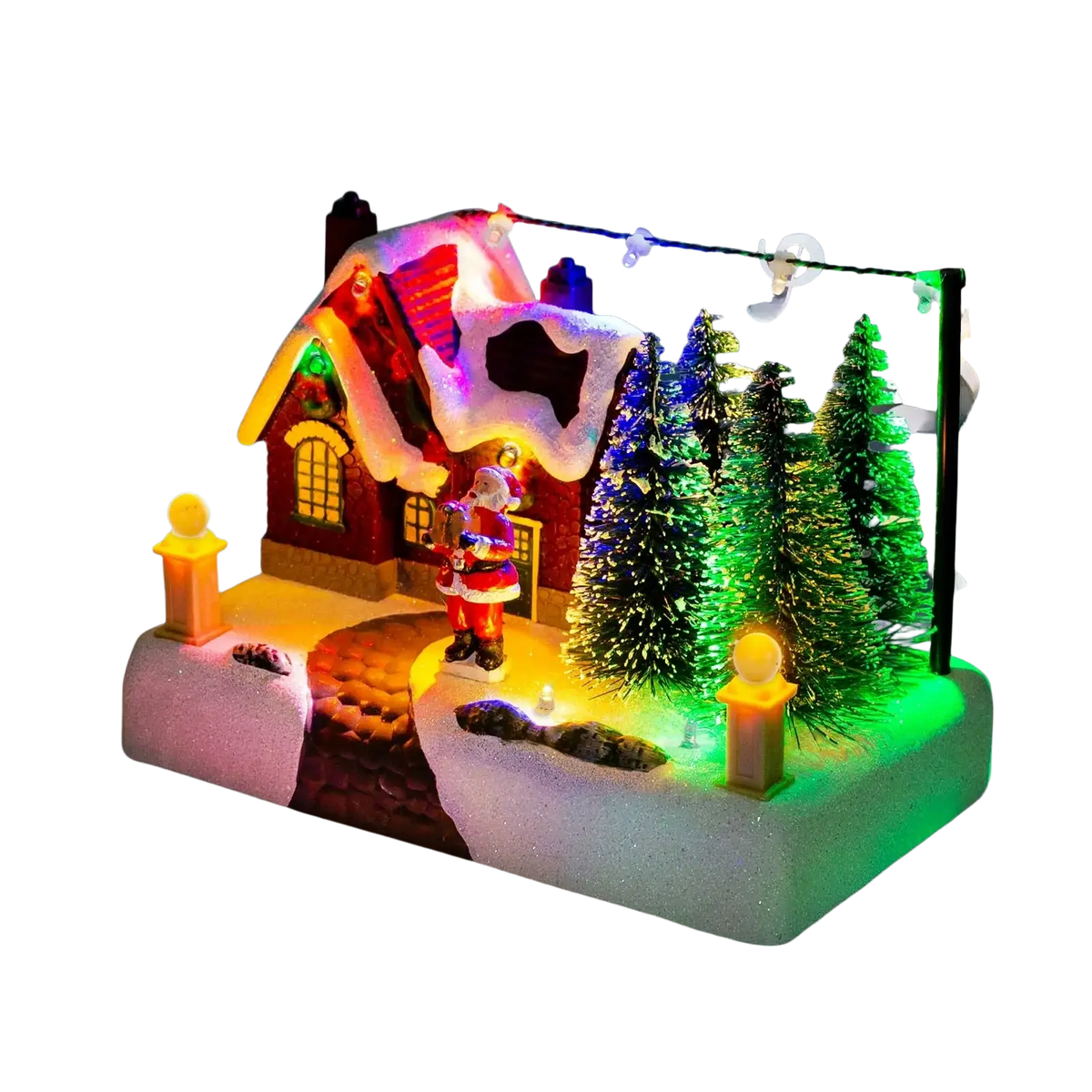 Led christmas village house featuring a red snow-dusted roof with santa and glowing windows surrounded by pine trees