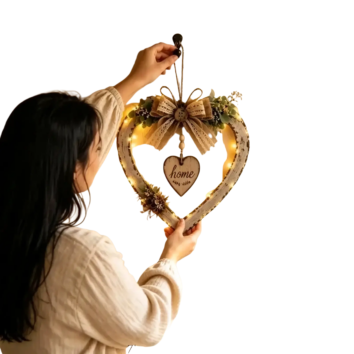 A rustic heart wall plaque with distressed white finish, warm LED lights, greenery, and central wooden home sign