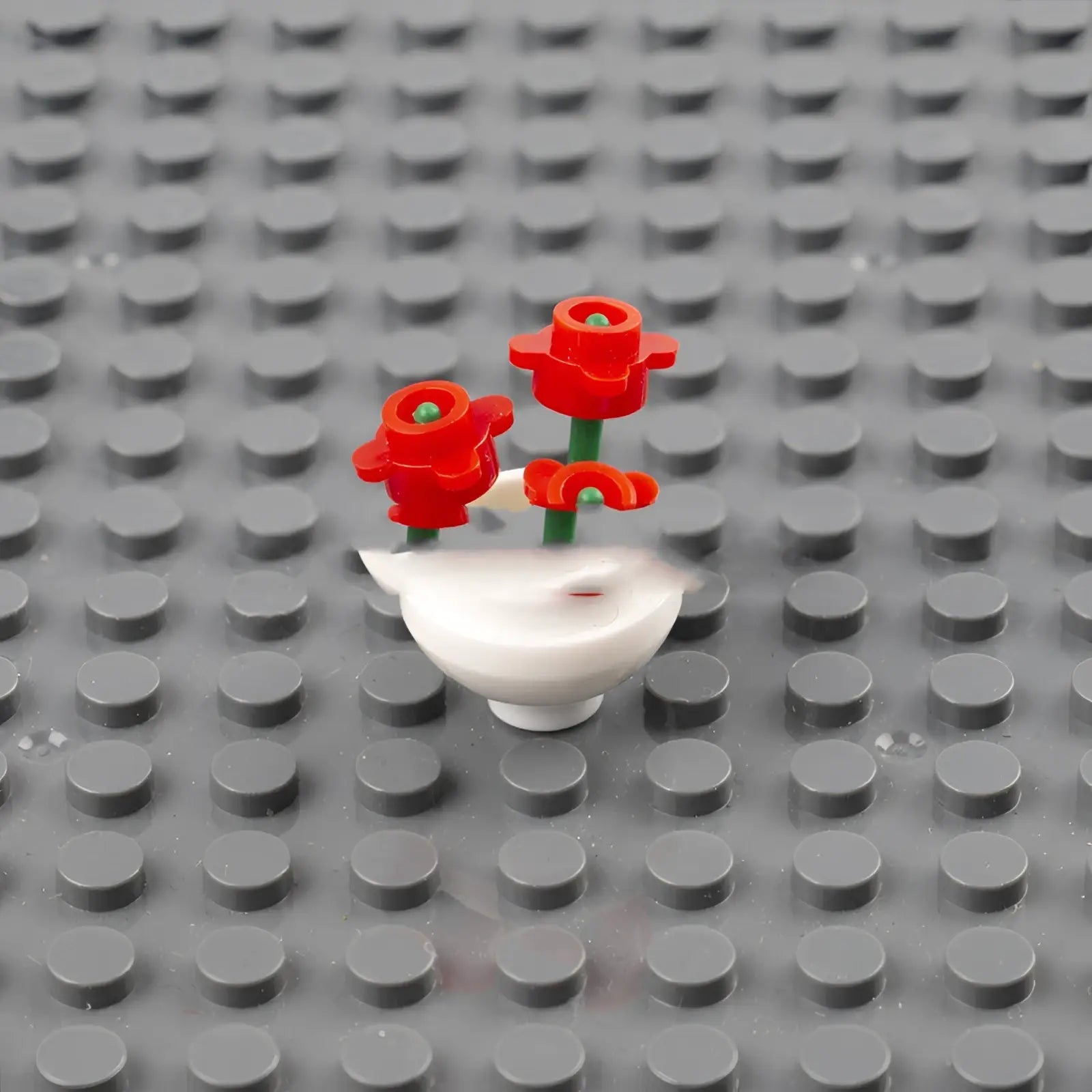 White lego flower vase building block set for kids with three red plastic flowers and green stems