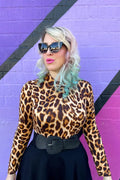 Vintage leopard print mock neck long sleeve top featuring a fitted silhouette and high neckline in warm tones