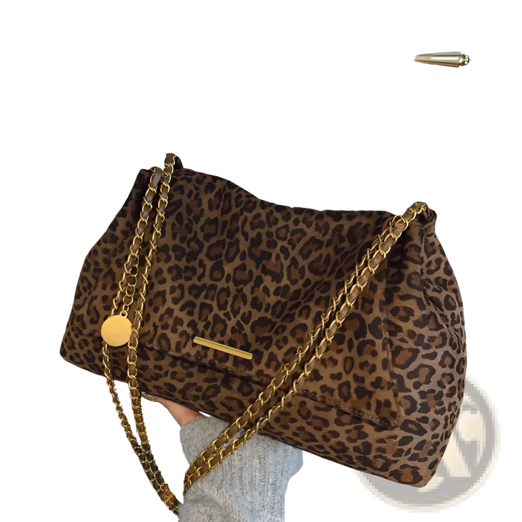 A brown leopard print crossbody bag with a gold chain strap and matching gold circular charm