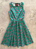 A vibrant green cotton 1950s flare dress with a pink leopard print fitted bodice and sleeveless design