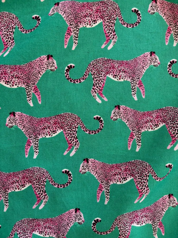 Vintage pink leopard print green cotton 1950s flare dress featuring vibrant pink cheetahs on teal fabric