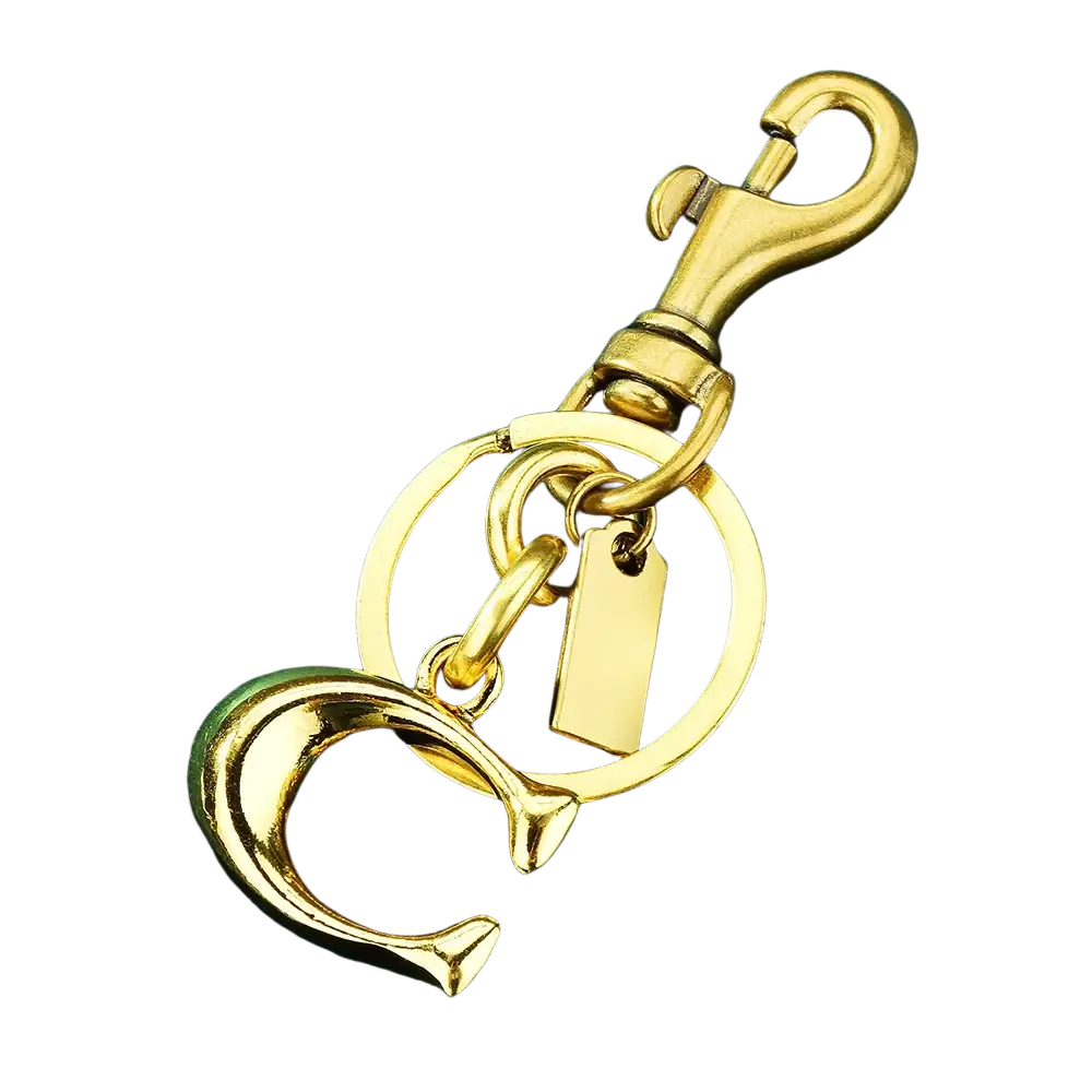 Gold-tone metal letter b keychain featuring an interlocking c logo, circular ring, and rectangular tag for car accessory