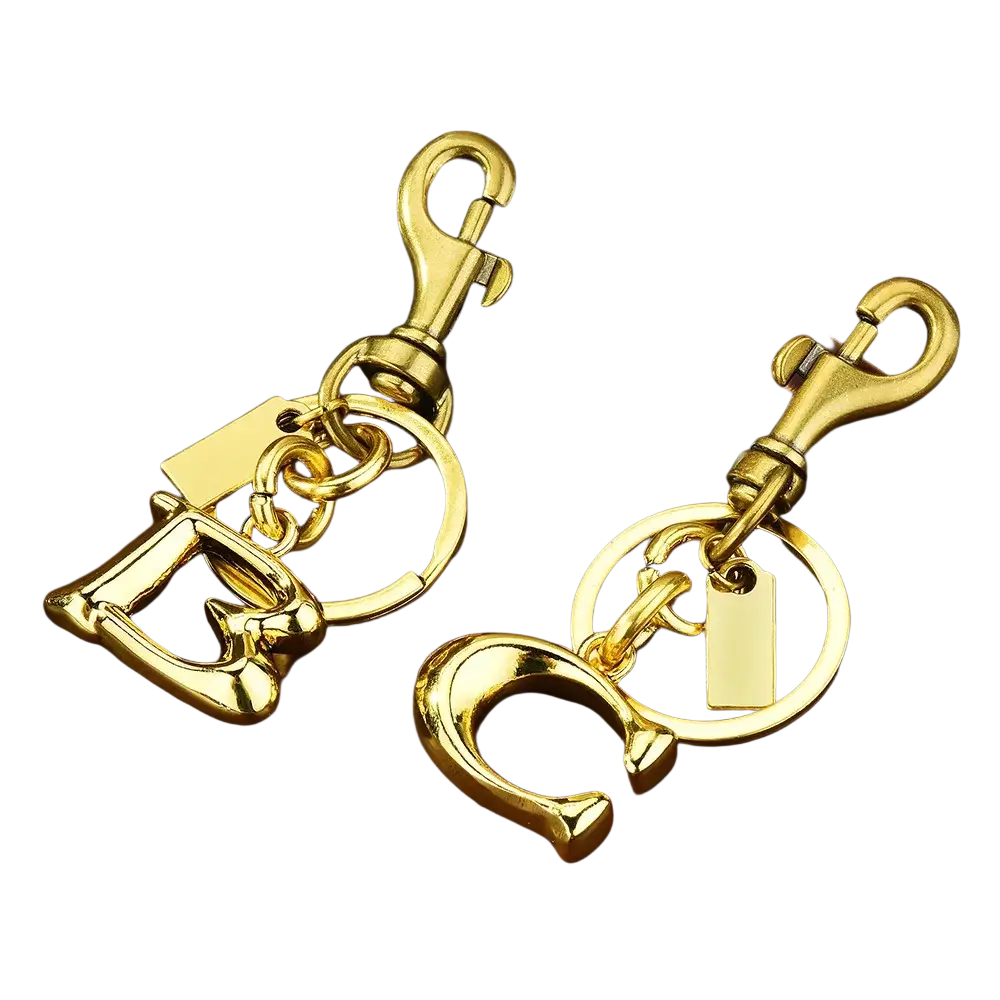 Gold-tone metal letter c and d keychain with polished finish attached to ring and swivel hook for car accessory