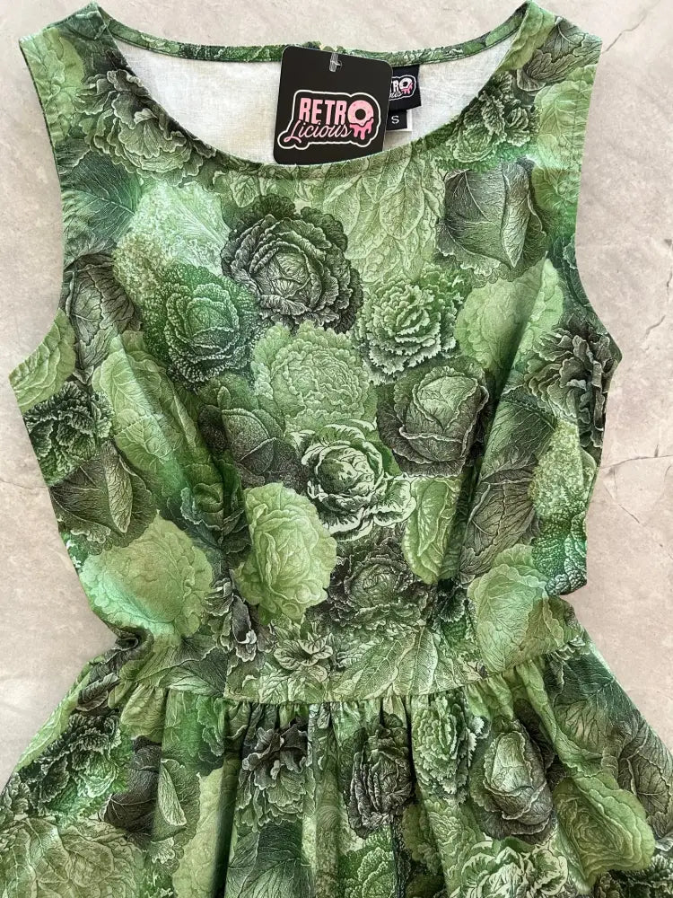 Vintage 1950s sleeveless cotton dress in green with detailed cabbage print and ruffled hemline