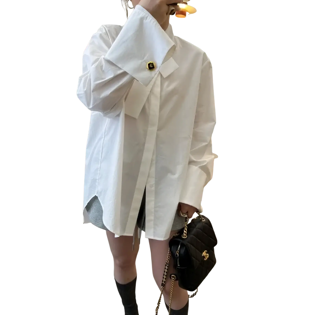 Black quilted chain shoulder bag with gold tone hardware paired with light blue oversized button up shirt