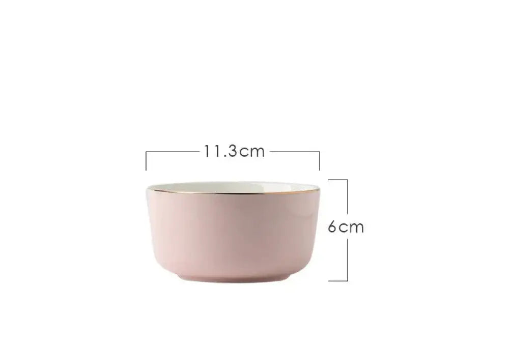 A blush pink ceramic bowl with a smooth glossy finish and gold rim from the luxury pink and gold script dinnerware set