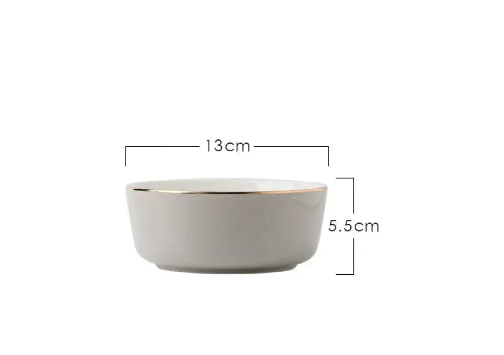 A sleek off-white ceramic bowl with a gold rim from the luxury pink and gold script ceramic couple dinnerware set