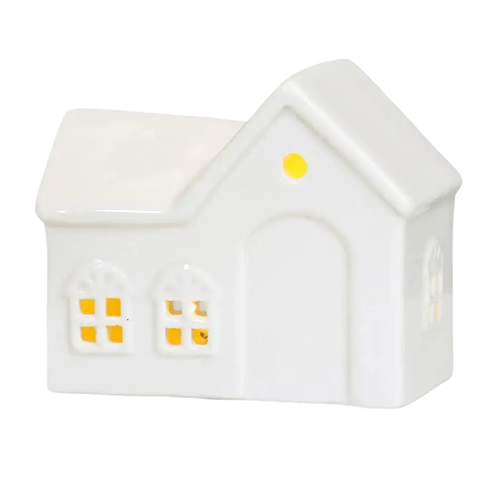 White ceramic house-shaped oil diffuser with yellow lit windows and roof light for christmas village houses decor