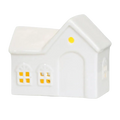 White ceramic house-shaped oil diffuser with yellow lit windows and roof light for christmas village houses decor