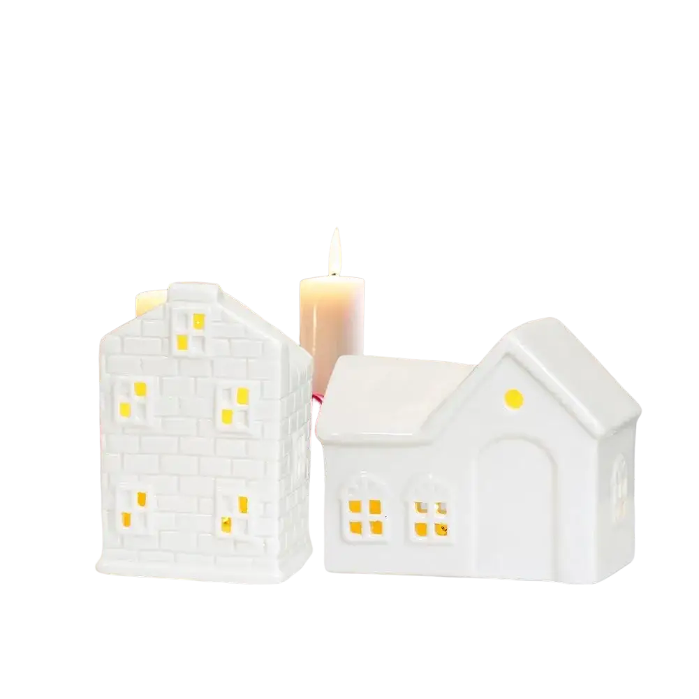 Two white ceramic christmas village houses with glowing led lights creating an enchanting winter wonderland scene