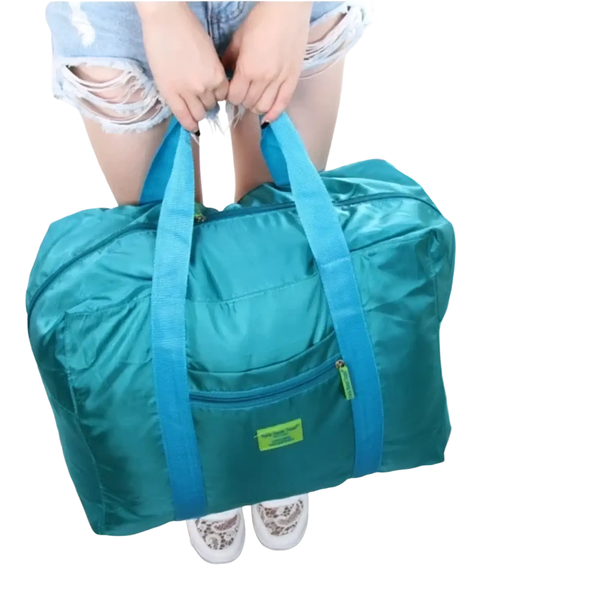 Lightweight foldable travel duffel bag in teal with blue handles and a green label for easy portability