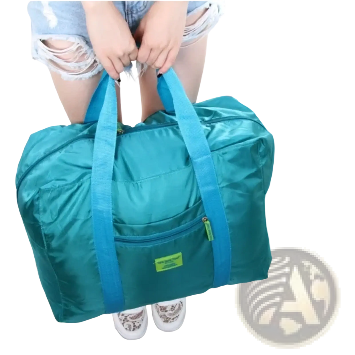 Lightweight foldable travel duffel bag in teal with blue handles and a green label for easy portability