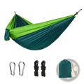 Lightweight nylon camping hammock in vibrant green and teal gradient with attached carabiners ropes and carrying bag