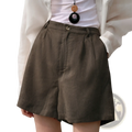 Olive green linen shorts with subtle textured pattern and button closure suitable for casual loose fit wear
