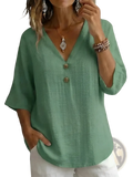 A soft sage green linen v-neck button top featuring three wooden buttons down the front