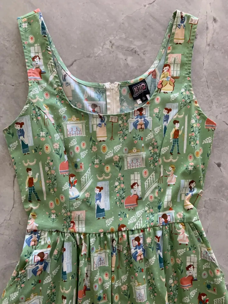 A green sleeveless fit and flare cotton dress with vintage-style characters and floral motifs featuring pockets