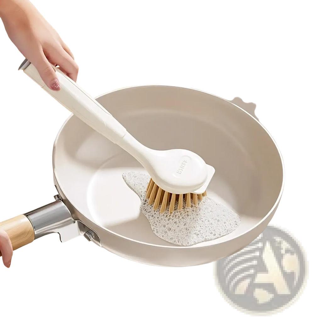 Long handle dish brush with white plastic handle and natural bristles scrubbing a beige frying pan for stove grease removal