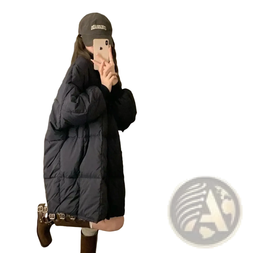 Long winter puffer coat for women in black quilted material with a long oversized silhouette and visible stitching patterns
