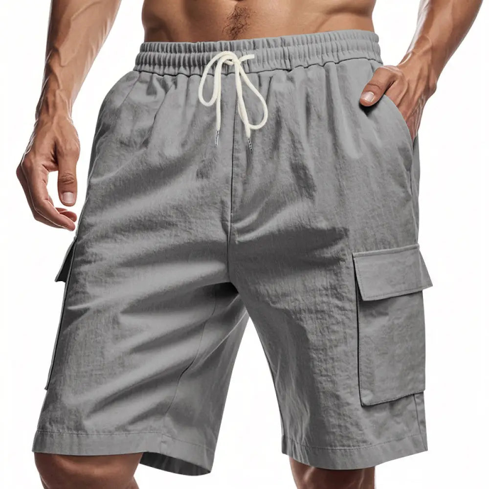 Men’s relaxed gray linen cargo shorts with multiple pockets and white drawstring waistband for casual wear