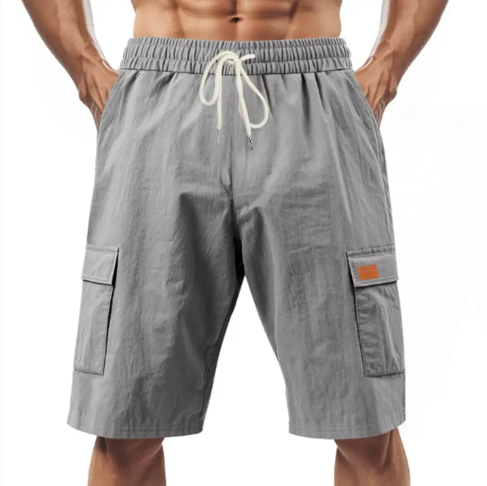 Men’s relaxed linen cargo drawstring shorts in gray with multiple pockets and an orange patch on the right thigh