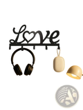 Black metal wall hook rack shaped like love with a heart replacing the o featuring five pegs for keys and accessories