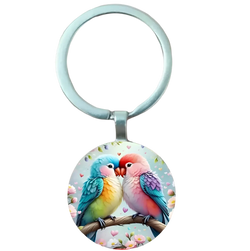 A round colorful glass dome lovebird keychain featuring two affectionate birds on a floral branch with hearts