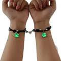 Black cord couple bracelets with glowing green paw print charms and silver heart-shaped magnetic clasp