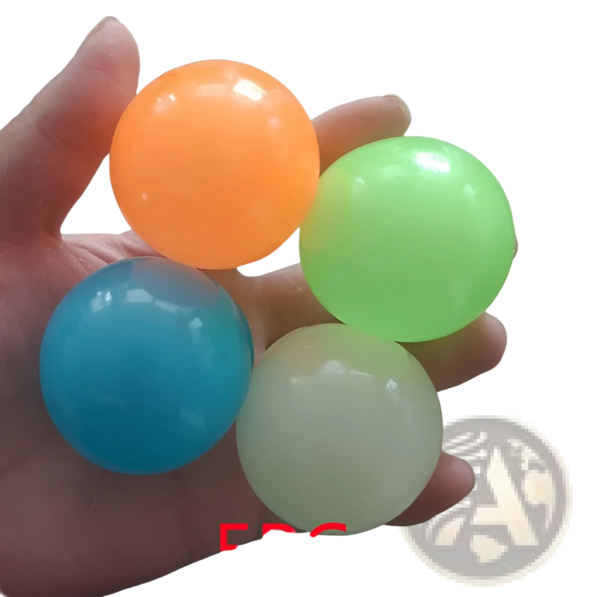 A hand holding four colorful translucent luminous sticky wall balls glow in the dark squeeze toys in orange green blue and pale yellow