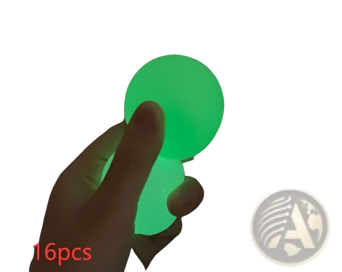 A hand holds a glowing green luminous sticky wall ball glow in the dark squeeze toy made of flexible silicone