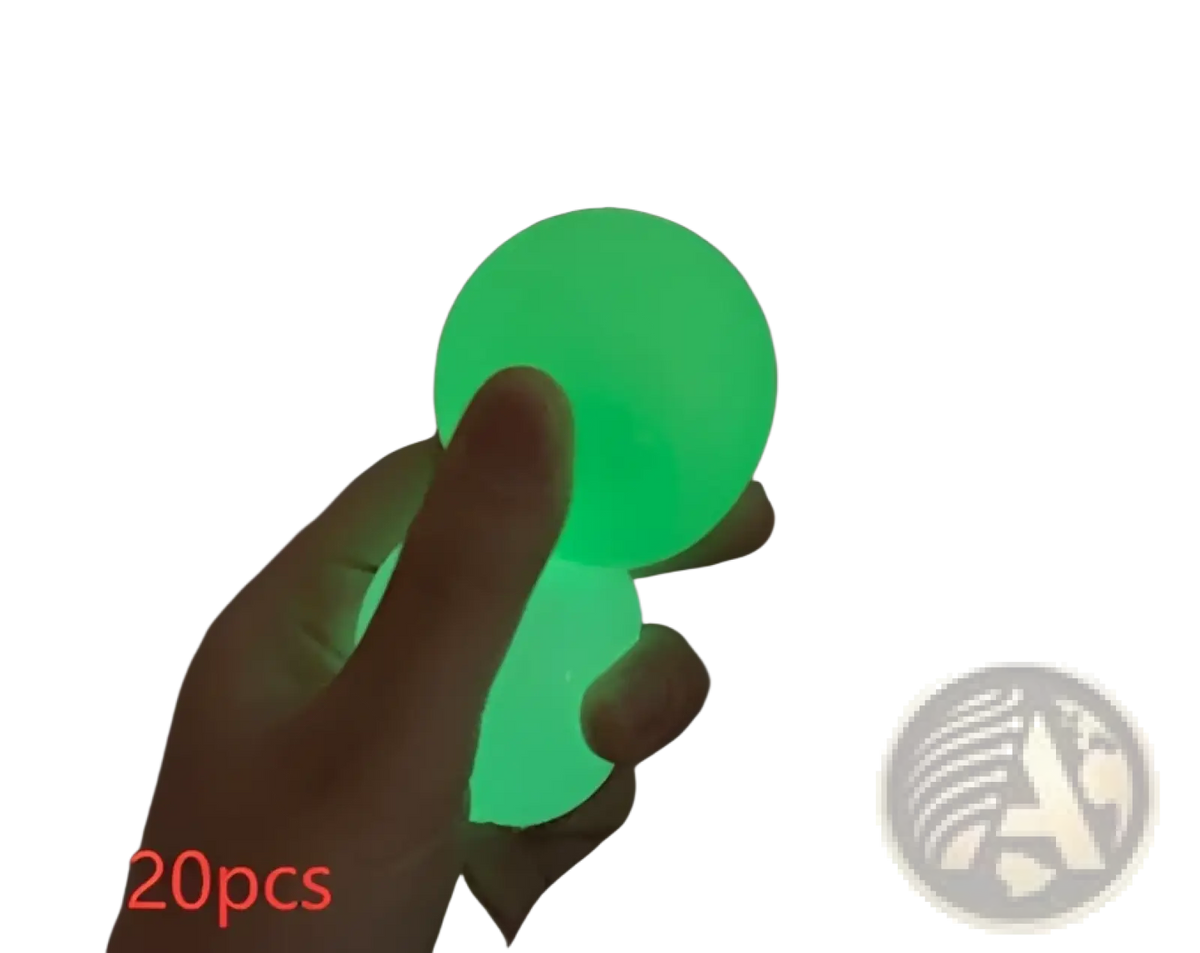A glowing green luminous sticky wall ball glow in the dark squeeze toy made of soft flexible material held in hand