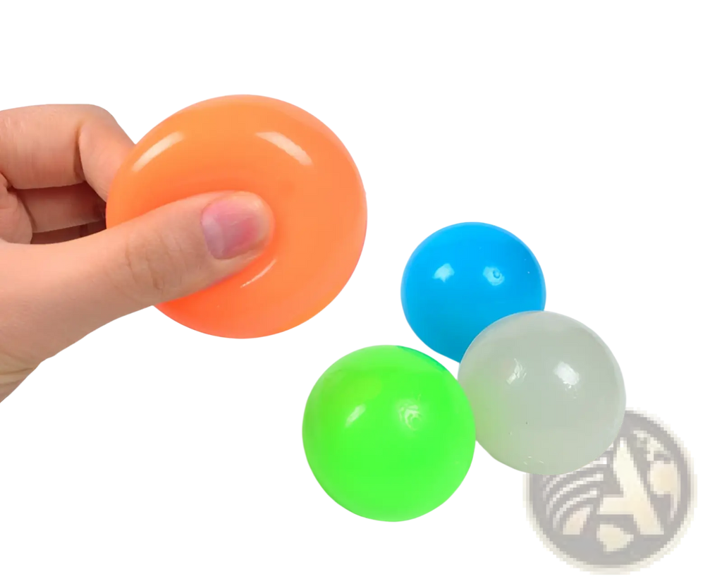Orange translucent luminous sticky wall ball glow in the dark squeeze toy held in hand for stress relief