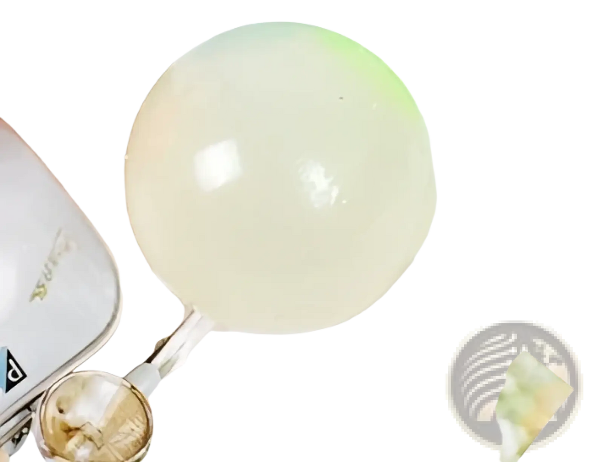 A translucent glossy white luminous sticky wall ball glow in the dark squeeze toy with smooth surface and internal reflections
