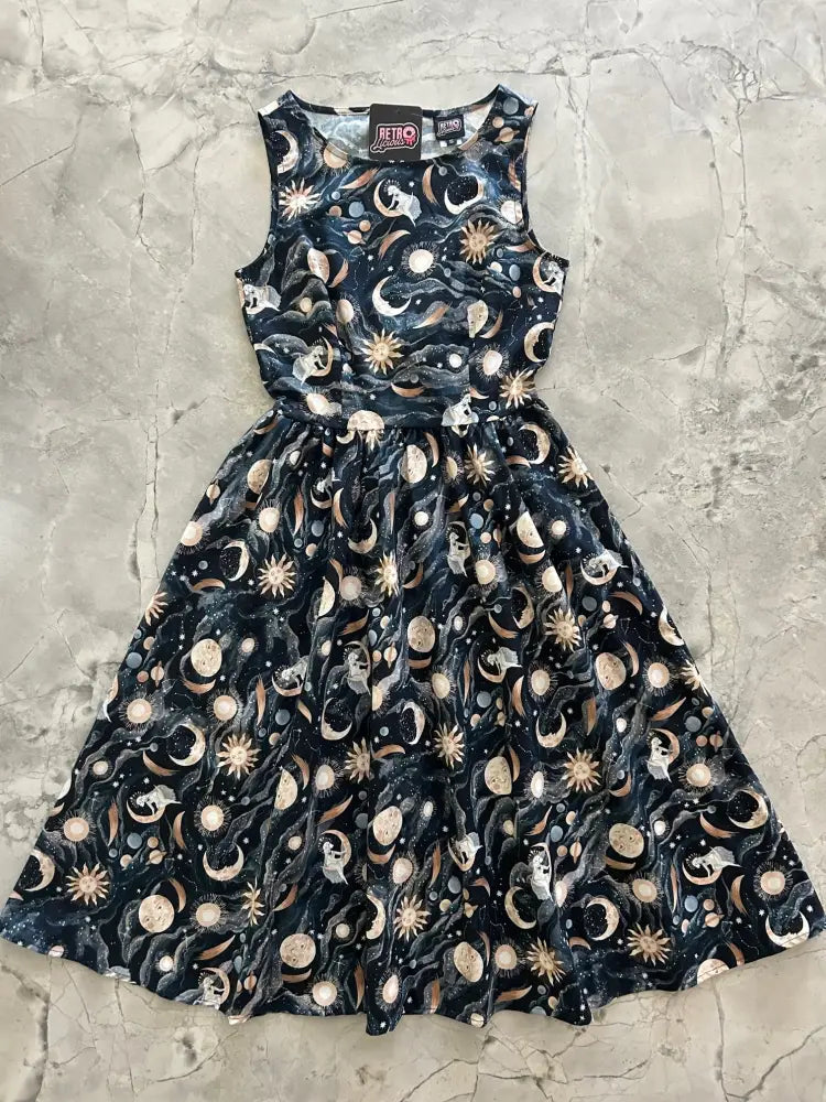 A sleeveless black cotton 1950s vintage midi dress with cream and gold celestial moons stars and cats print