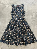 A sleeveless black cotton 1950s vintage midi dress with cream and gold celestial moons stars and cats print