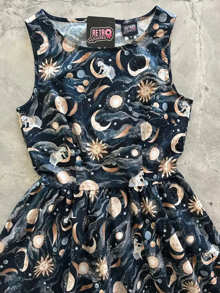 Sleeveless dark navy cotton 1950s vintage midi dress with whimsical gold and white celestial print featuring moons suns and planets