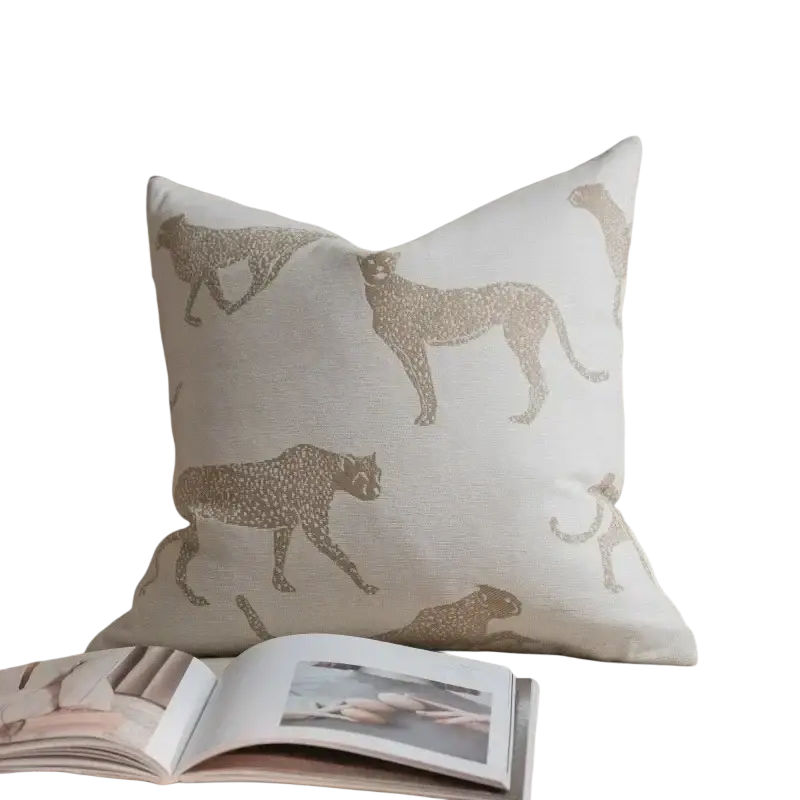 Cream-colored luxury cushion cover oatmeal featuring gold-toned cheetah silhouettes in geometric jacquard pattern