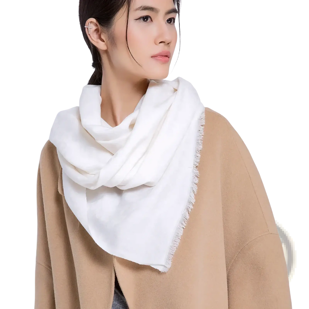 Luxury wool scarf for women in white with frayed edges draped around the neck